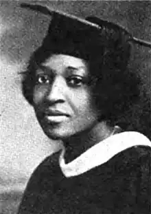 Portrait photograph of young black woman wearing a college graduation cap