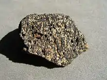 A speckled rock with black (ilmenite) and white (apatite) grains