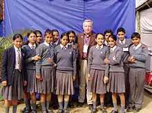 Uniformed schoolchildren with an adult, possibly their teacher