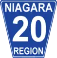 Niagara Regional Road 20 marker. While Niagara generally conforms to the standard Ontario "flowerpot" design, the markers are white-on-blue rather than the more traditional black-on-white and have rounded corners.