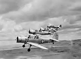 Three-quarter view of four military monoplanes in flight