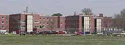 Three-story brick buildings surrounded by high wire fence