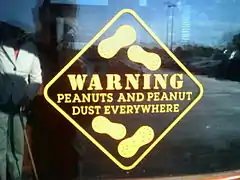 A warning sign for the presence of peanuts and peanut dust