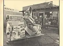 person in truck passing boxes to people on the ground