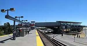 An elevated rapid transit station with a second platform connected at one end