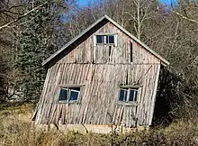 A wood-framed clapboard house, the walls WAY out of plumb.