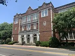 Large three-story brick building with a triple stone door.