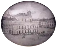 Photograph showing the Imperial Palace in Rio de Janeiro with carriages and mounted honor guard in the square fronting the palace.