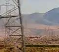 Pacific DC Intertie towers (left side) near Fernley, Nevada. The first few towers are self-supported. The towers on the far side use guy-wires.