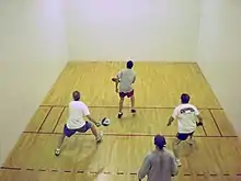 Four men playing paddleball