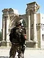 An ISAF soldier standing by the ruins of the Victory Arch in 2004, before its renovation