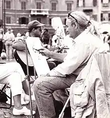 A photograph depicting Italian xpressionist painter Paolo Salvati while painting in Piazza Navona