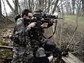 Three airsoft team members during a field game.