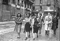 Three partisan girls armed with rifles in Via Brera (Milan), 26 April 1945