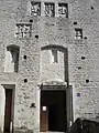 Entrance door with several coats of arms of the former owners