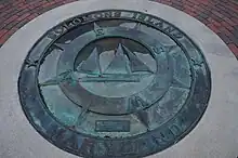 A visitors' wayfinding compass-marker on Solomons Island picturing a bugeye boat