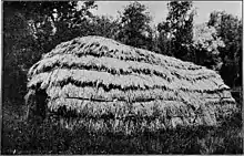 Home made of many horizontal layers of straw, creating a long and narrow structure