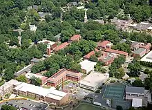 Low-rise brick academic and residence buildings, along with tennis courts and sports facility