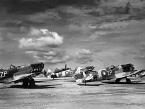 Three monoplane aircraft on the ground. All three aircraft have had their forward propellers removed.