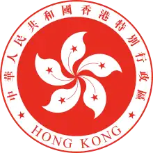 A red circular emblem, with a white 5-petalled flower design in the centre, and surrounded by the words "Hong Kong" and "中華人民共和國香港特別行政區"