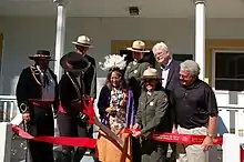 A photo of Congressman George Miller, Mayor Rob Schroeder, Superintendent Naomi Torres, Linda Yamane, Regional Director Christine Lehnertz, Lance Beeson, Lauren Kardel, & Superintendent Martha Lee as they "cut the ribbon" and celebrate the Grand Opening of the Martinez Adobe, home of the new permanent Juan Bautista de Anza Trail Exhibit in Martinez, CA.