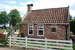 A tiny house, Jan Boer's bust, and the church in the background