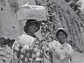 "Two Negro women carrying packages, one has a box of surplus relief commodities on her head. Natchez, Mississippi", 1940