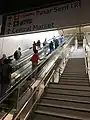 Escalators from the MRT station concourse level to the pedestrian link bridge.