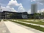 View of the ground level plaza of the Pasar Seni MRT station with the glass entrances and the Pasar Seni LRT Station at the back.