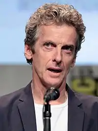 Peter Capaldi seated with microphone