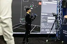 An exhibitor at SIGGRAPH 2023 demoing a full-body motion capture suit.