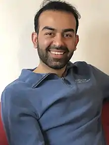 Portrait of Safi Rauf from the waist up, wearing a blue shirt.