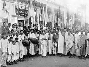 A group of India people with drums and flags in a semicircle