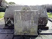 Medieval stone sarcophagus of Tigernach, with a modern inscribed slab giving details of his life. In the graveyard by the round tower at Clones.