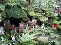 Small Inari statues and moss covered miniature shrines