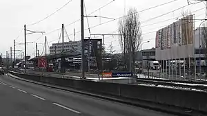 Double track with island platform next to carriageway