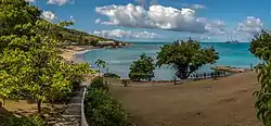 View of Sea Grapes Beach at the Rex Resorts’ Hawksbill Hotel at  Five Islands with world’s largest yacht at anchor off Hawksbill Bay.