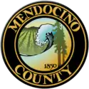 The county's official seal, in chief two redwood trees and the numbers '1850', a breaking wave on the Pacific Ocean and a vineyard set in relief, bordered by a dark brown circle with the words 'Mendocino County' appearing within the border in gold block letters