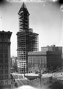 The Smith Tower, designed by Gaggin & Gaggin of Syracuse, New York; completed 1914, shown here under construction in 1913. At 38 stories, it was tallest office building west of the Mississippi River until the Kansas City Power & Light Building (1931), and the tallest building on the West Coast until the Space Needle (1962).