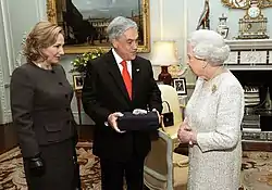 Color image of Chilean President Piñera and the First Lady present a souvenir gift rock from the San Jose Mine to Elizabeth II on 18 October 2010 during a state visit to the UK