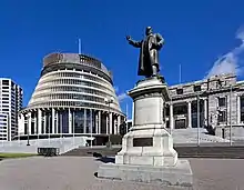 A block of buildings fronted by a large statue.