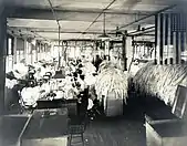 A long row of women inside of a factory