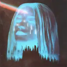 The computer graphic of a woman's head that is blue and transparent, floating in the darkness, with a beam of multi-colored light coming from her forehead