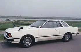 Side view of a two-door car with wing mirrors