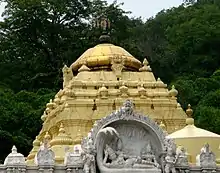 A three-tier pyramid like structure with a golden dome on its top.