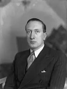 Man (William Walton) in suit and tie looking towards the camera