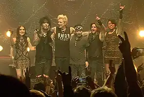 Sixx:A.M. in 2015. From left to right: Melissa Harding, Nikki Sixx, James Michael, DJ Ashba, Dustin Steinke and Amber Vanbuskirk