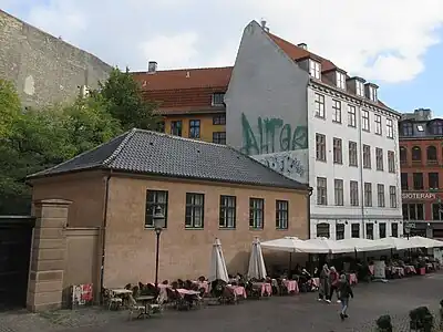 The building viewed from Fiolstræde. The Mansard roof towards the yard is just visible above the low building.