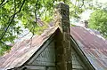 Detail of the farm house showing gable, chimney, and roof