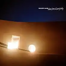 Three mirrors of different shapes and sizes standing up on a sand dune, reflecting a bright white light.